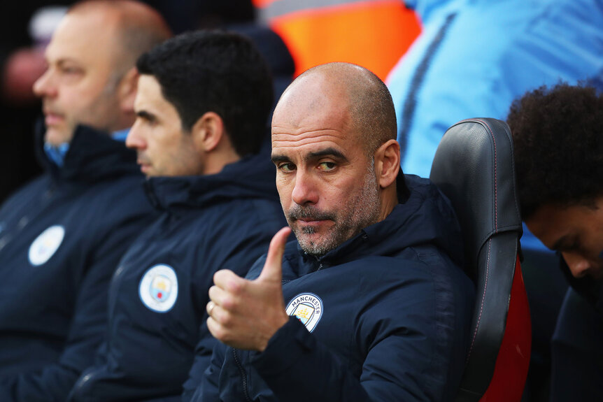 Josep Guardiola giving a thumbs up during a match