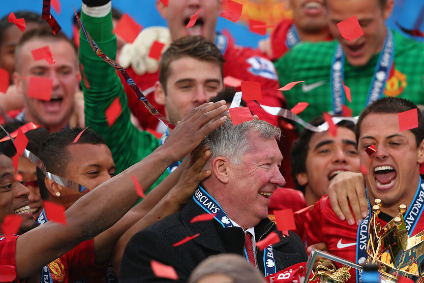 Manchester United Manager Sir Alex Ferguson celebrates with his players and the Premier League trophy