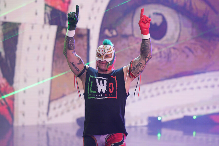 Rey Mysterio raises his arms above his head and he walks ti the ring