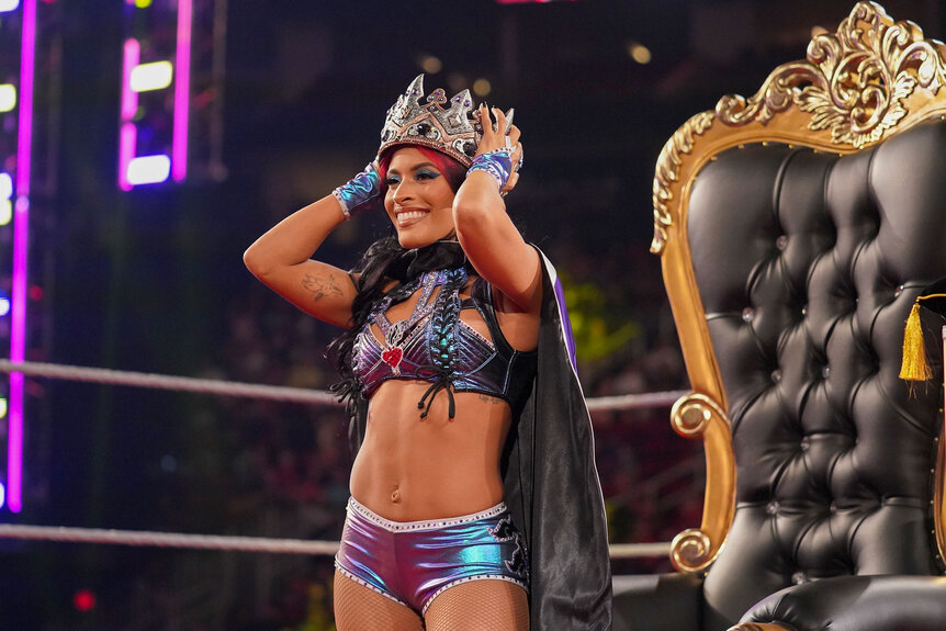 Zelina Vega puts a crown on her head while standing in the middle of the ring