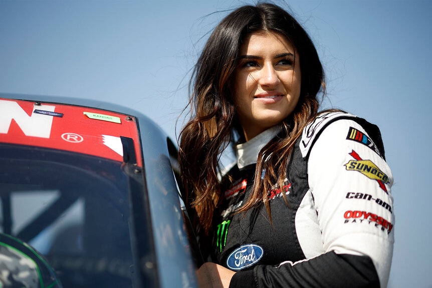 Hailie Deegan smiles as she climbs into her car