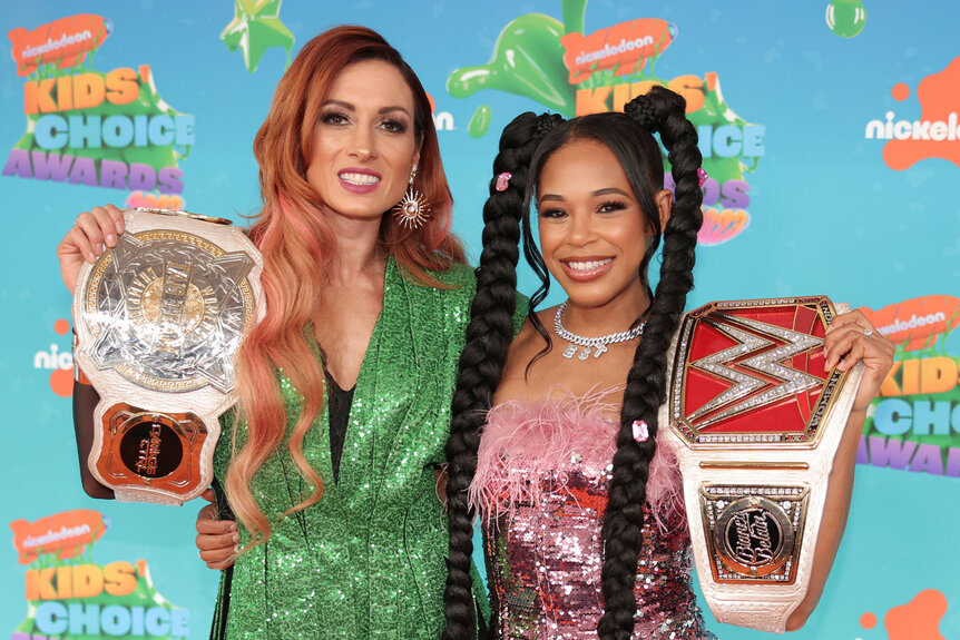 Becky Lynch and Bianca Belair pose together with their championship belts
