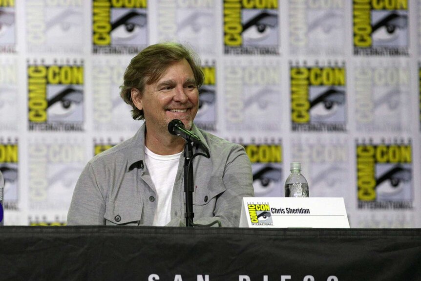 Chris Sheridan smiling on stage at San Diego Comic-Con 2025