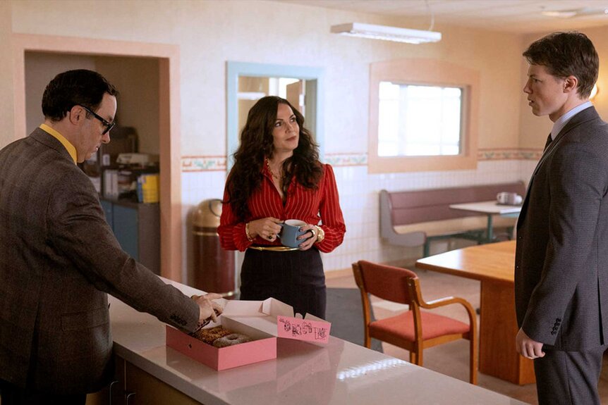 The Rainmaker stars gathered around a box of donuts